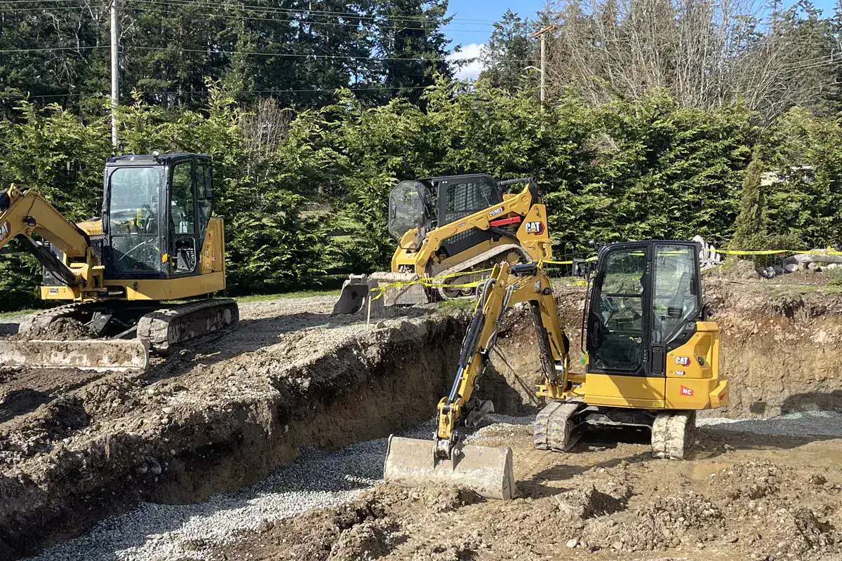 Excavators working a foundation and utility trench